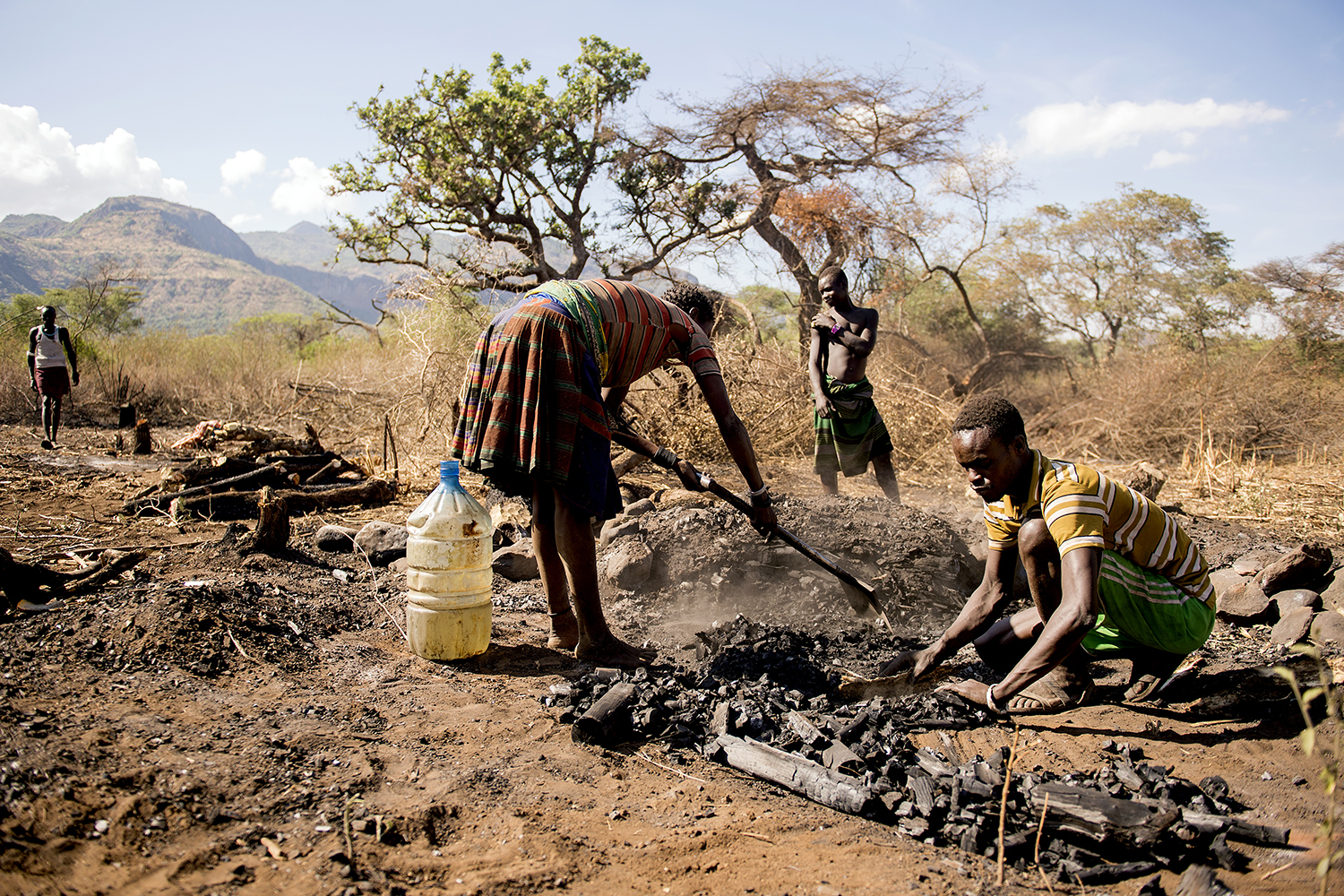 Ægtepar fremstiller trækul på et bål i Uganda