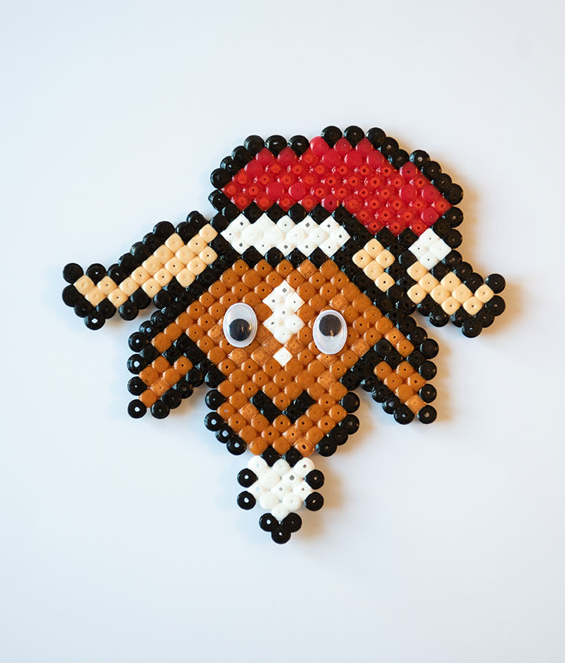 En ged med en nissehue på lavet af perler.