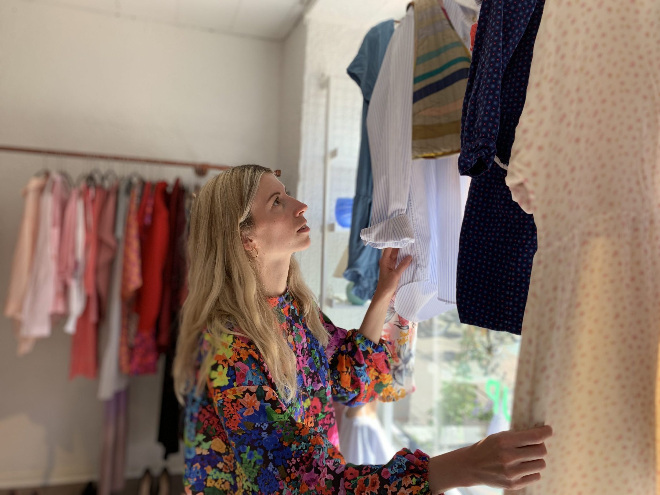 Kvinde, der handler i en af Folkekirkens Nødhjælps genbrugsbutikker