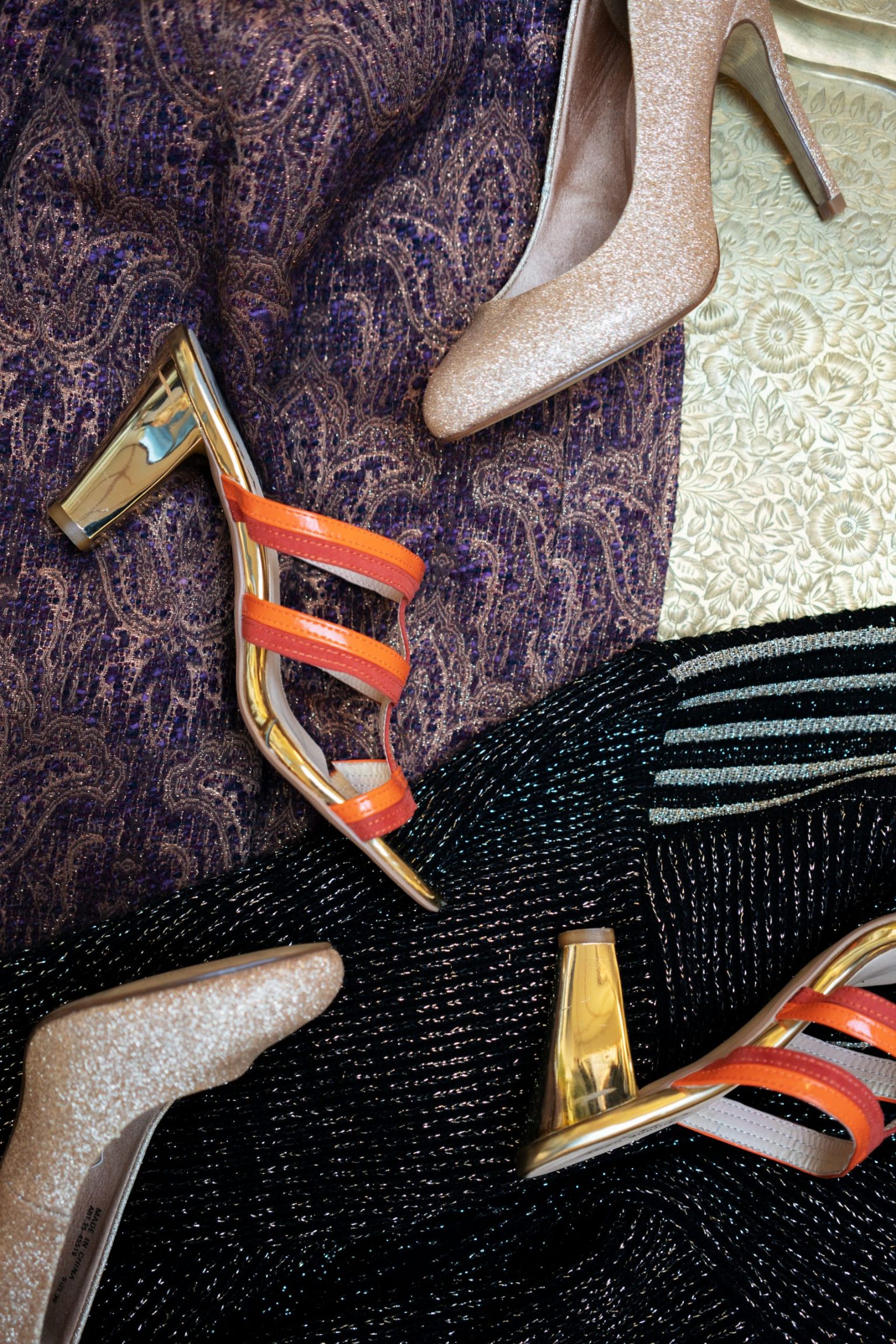 Stiletter ligger p&aring; nogle fine kjoler