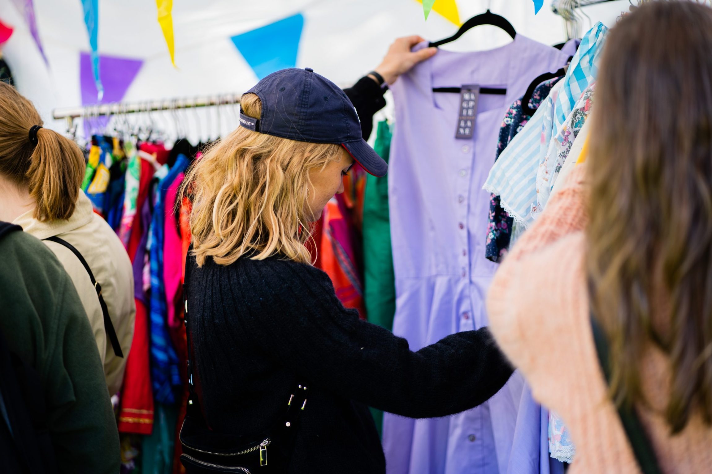 Kvinde i genbrugsbutik kigger p&aring; en kjole.