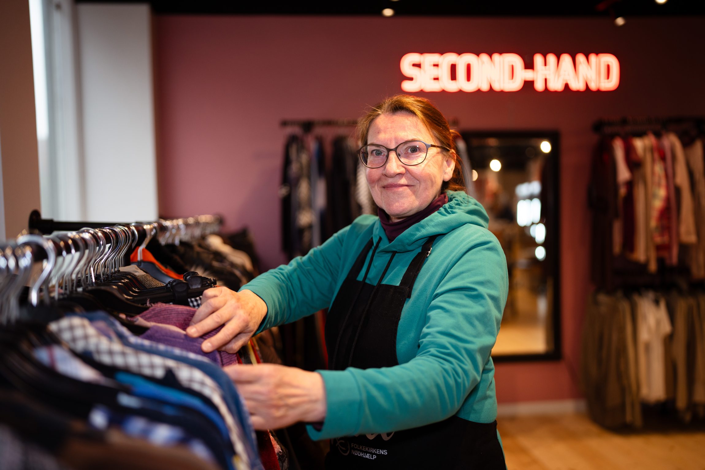 Frivillig i en af Folkekirkens N&oslash;dhj&aelig;lps mange butikker