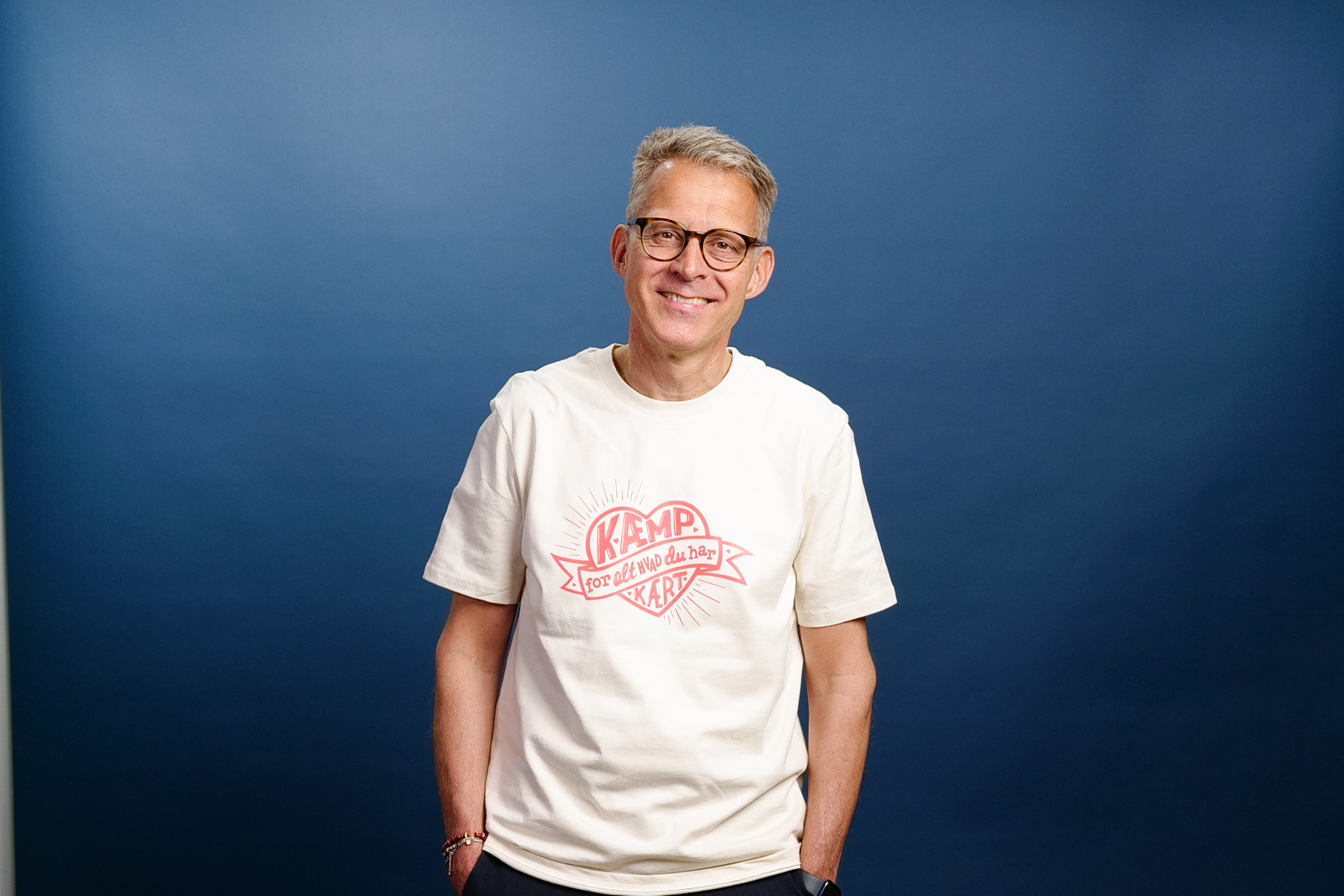 Mandlig model b&aelig;rer st&oslash;tte-tshirten 'K&aelig;mp for alt, hvad du har k&aelig;rt' udviklet i samarbejde mellem Kritisk Pynt og Folkekirkens N&oslash;dhj&aelig;lp.